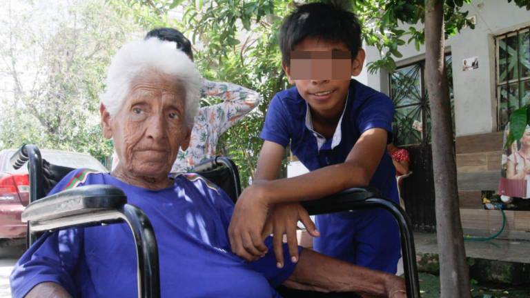 Doña Rita Orozco, de 81 años de edad, cuida a su nieto Jaime, de 12 años.