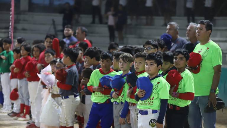 Los pequeños peloteros rinden honores a la bandera durante la ceremonia inaugural.