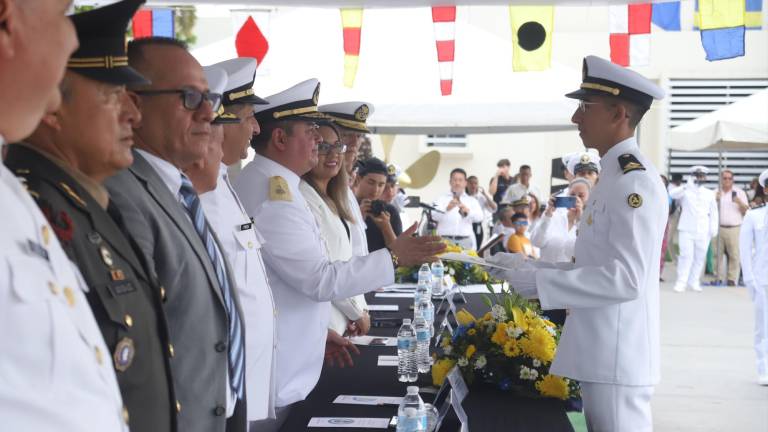 José Rodrigo Villalobos, primer lugar en aprovechamiento en la Licenciatura de Maquinista Naval, recibe sus documentos.