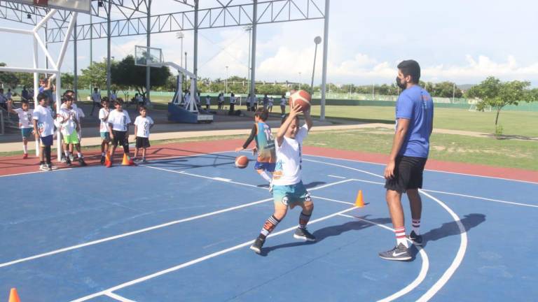 Alumnos desde los 5 hasta los 18 años de edad se instruyen en el baloncesto.