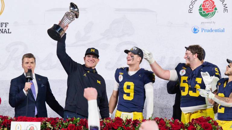 El entrenador de Michigan Wolverine, Jim Harbaugh, levanta el trofeo que los acredita como ganador del Rose Bowl 2024.