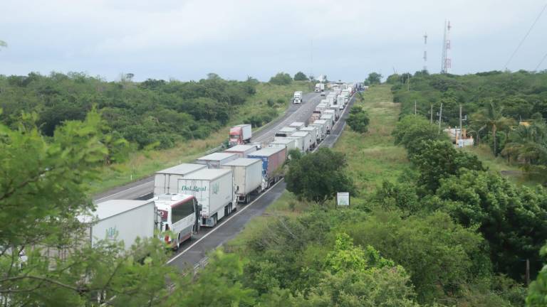 Decenas de vehículos, entre ellos tráileres, autobuses y unidades particulares, permanecieron varados tras el cierre del sentido de sur a norte de la autopista Mazatlán-Culiacán.
