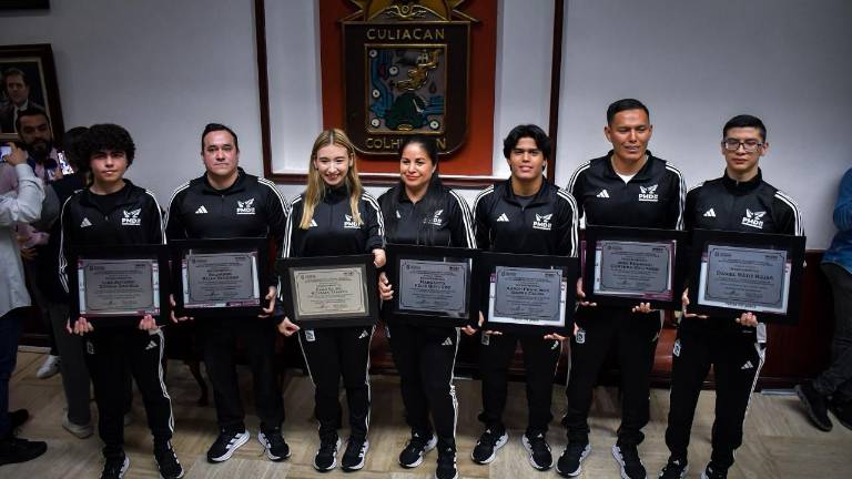 Los deportistas y entrenadores muestran sus reconocimientos.