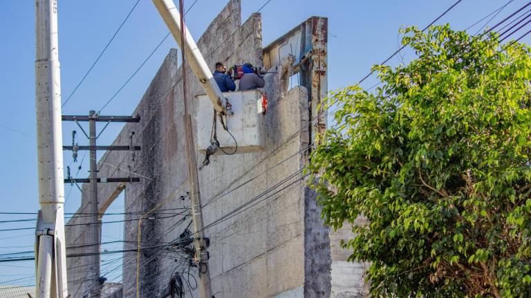 Trabajadores realizan la demolición de la barda en la colonia Tierra y Libertad para reducir riesgos a estudiantes de un jardín de niños.