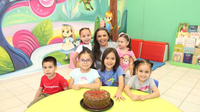 Los pequeños talleristas de “La hora del cuento” festejan con un pastel, el cumpleaños de la maestra Maury Rubio.