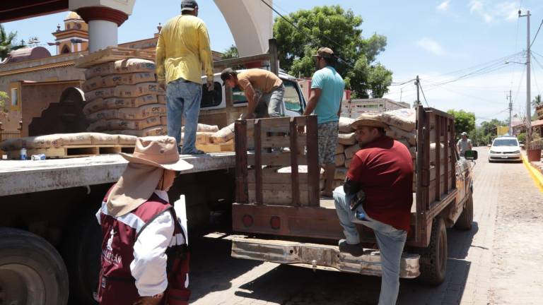 De un camión fueron descargados decenas de sacos de cemento para entregarlos a los beneficiarios.