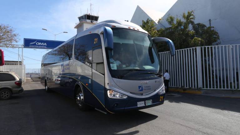 El autobús que transporta al equipo del Atlas sale de las instalaciones del aeropuerto.
