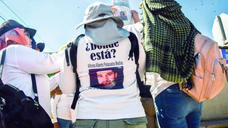 Las mujeres visten playeras blancas de manga larga con la fotografía de sus seres queridos estampada en el pecho y espalda, acompañada de un número telefónico.