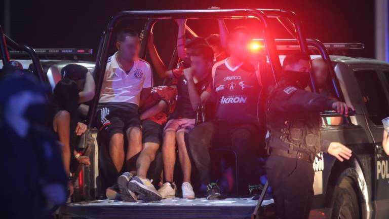 Aficionados del Atlas son transportados en una patrulla tras ser detenidos al finalizar el encuentro entre Mazatlán FC y los Rojinegros.