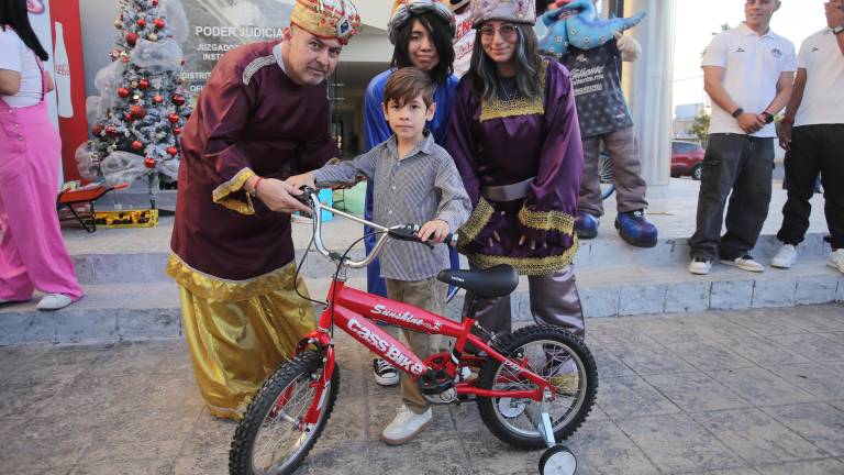 Melchor, Gaspar y Baltasar entregan a Mauricio una bicicleta.