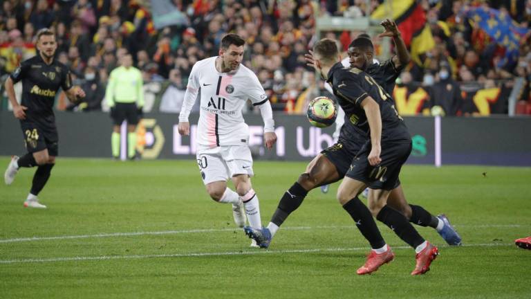 Lionel Messi intenta filtrar el balón entre dos adversarios.