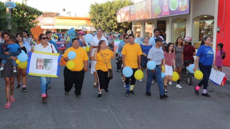 Un grupo de personas con calcetines de impares y camisas amarillas marcharon por las calles de Escuinapa.