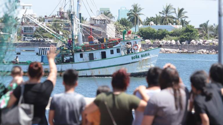 Familiares y amigos despiden a los pescadores que zarpan rumbo a altamar.