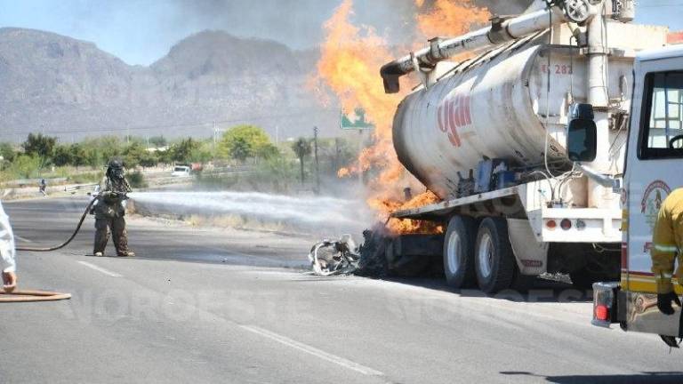 Personal de Bomberos de Los Mochis realiza labores para sofocar el fuego en la cabina de la unidad.