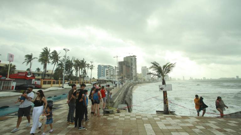 Turistas y locales acuden al malecón de Mazatlán para observar el embravecido mar y disfrutar de un clima más fresco que el habitual.