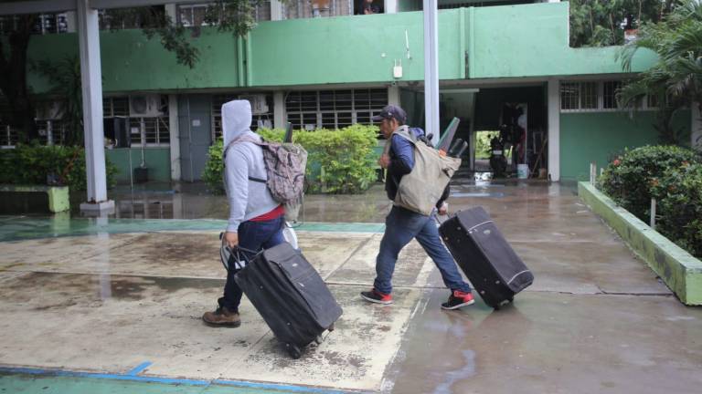 Personas llegan al refugio temporal ubicado en el Cobaes 39 en Villa Unión.