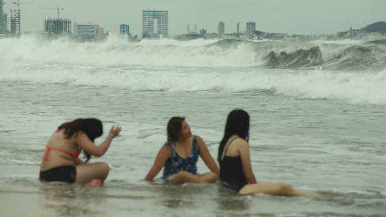 Mientras las autoridades informan que las playas de Mazatlán están cerradas por el fuerte y elevado oleaje, los bañistas disfrutan del mar porque no hay nadie que les informe sobre la restricción.