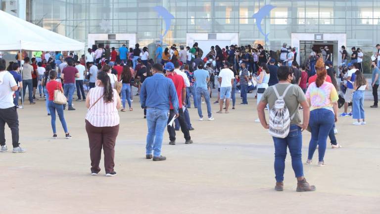 Jóvenes esperan ser vacunados en el Centro de Convenciones.