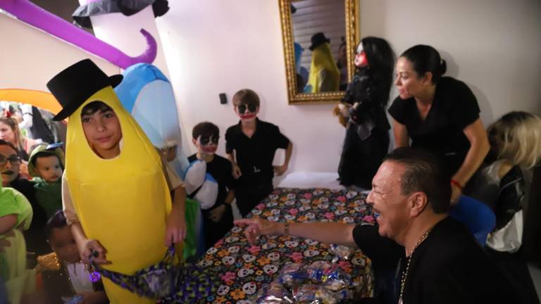 Julio Preciado muy contento celebra 28 años repartiendo dulces a niños en Halloween.