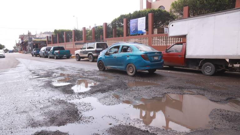 Pozos de todos tamaños y llenos de aguas negras afectan la circulación en la calle Enrique Pérez Arce.