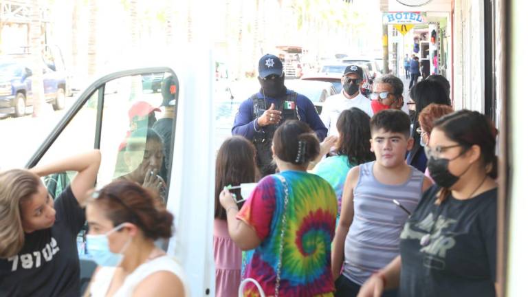 La Policía Municipal le indica a los turistas el uso correcto del cubrebocas.