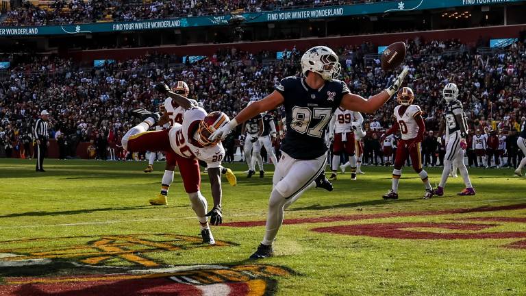 Jake Ferguson, al momento de quedarse con el ovoide para un touchdown de los Cowboys.