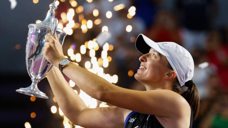 Iga Swiatek muestra el trofeo de campeona de las Finales de la WTA, alcanzado en Cancún.