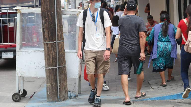 Turistas del crucero Carnival Panorama recorren el Centro de la ciudad.