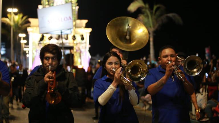 La banda entonando Los Papaquis anuncia la llegada de la carroza real en el desfile del Carnaval de Mazatlán.