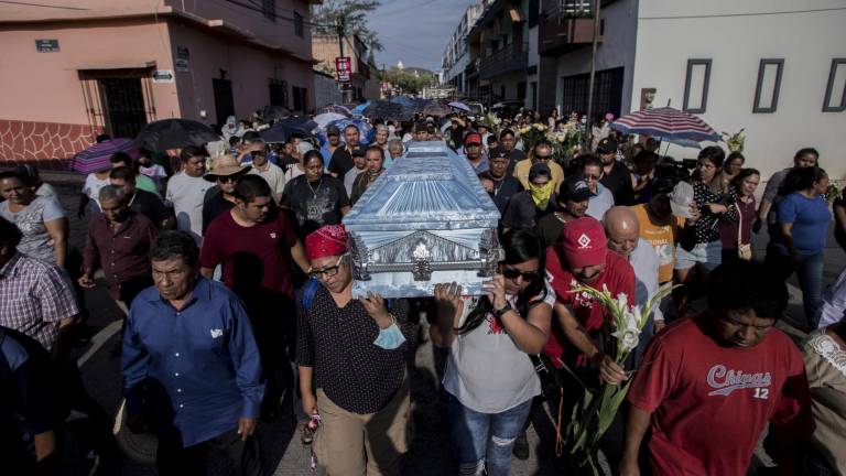 Mujeres integrantes de colectivos de búsqueda de personas desaparecidas cargan el ataúd de Mario Vergara en su recorrido, desde la iglesia de Huitzuco hasta el panteón municipal, el pasado 19 de mayo.