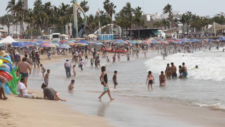 Turistas y locales conviven en la playa de Mazatlán durante el domingo de Semana Santa.