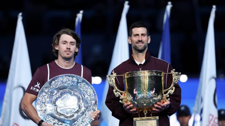 Novak Djokovic posa con su trofeo de campeón de Pekín junto a Alex de Miñaur.