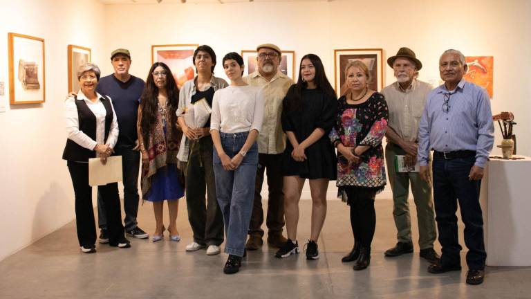 Los artistas posan en junto a la exposición.
