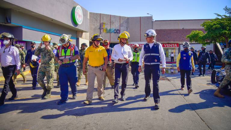 Personal de diferentes dependencias recorren la zona incendiada de una plaza comercial en Los Mochis.