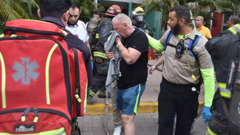 Uno de los vecinos del edificio donde se registró un incendio auxiliado por personal de Bomberos de Culiacán.
