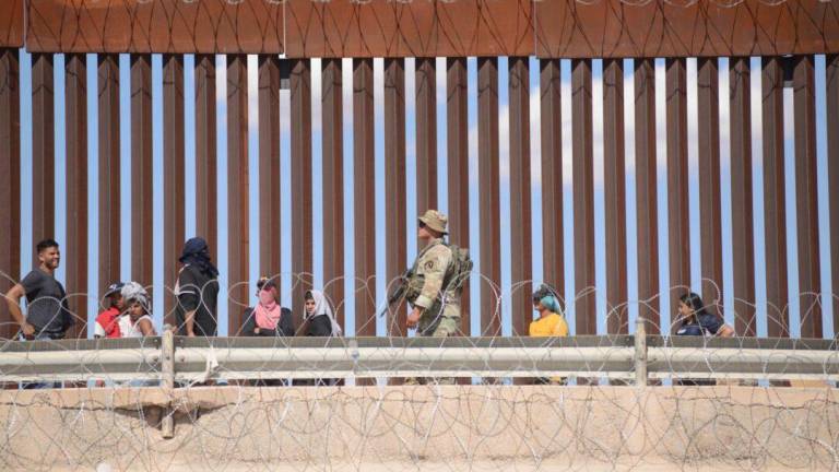 En el muro fronterizo entre Ciudad Juárez y El Paso, Texas, migrantes se aglomeran a la espera de asilo.