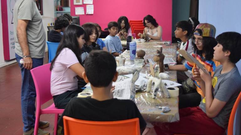 Adolescentes participan en el taller Fábrica de monstruos mágicos.