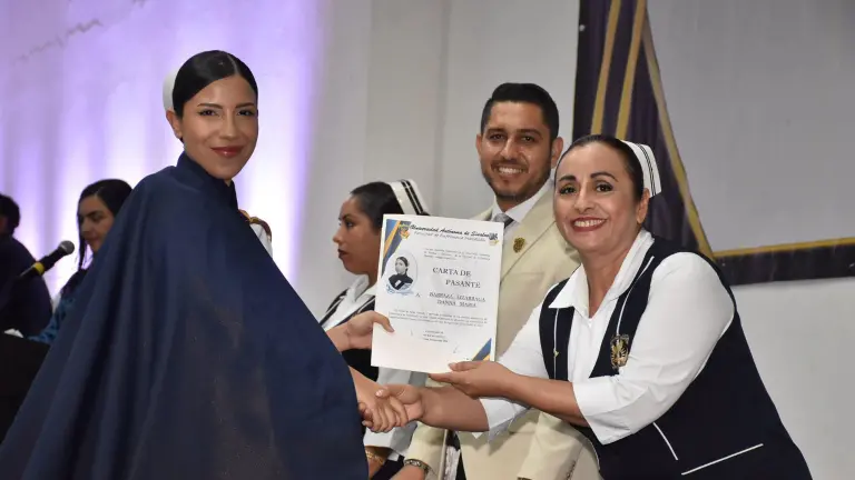 Danna María Barraza recibe su carta de pasante de manos de Alma Delia Frayre de la O.