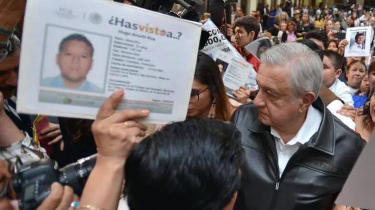 Familiares de personas desaparecidas protestan en Palacio Nacional, el 24 de marzo de 2019, durante el acto de reinstalación del Sistema Nacional de Búsqueda, presidido por López Obrador.