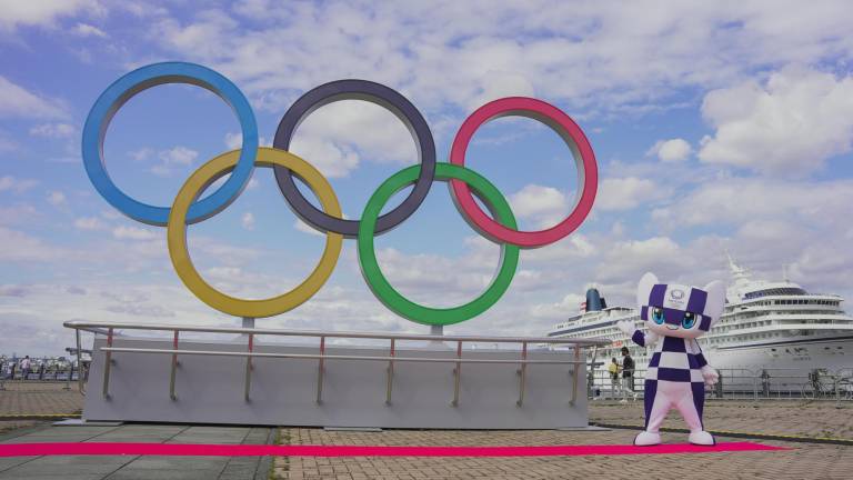 La mascota de los JJOO de Tokio posa junto a los aros olímpicos.