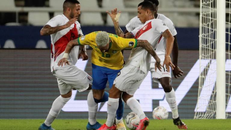 Neymar intenta pasar entre dos defensores peruanos.