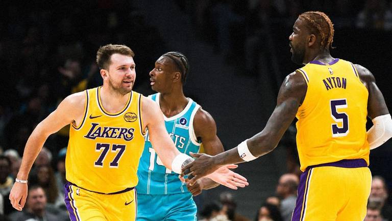 Luka Doncic es felicitado por Deandre Ayton, en el triunfo de los Lakers sobre los Hornets.
