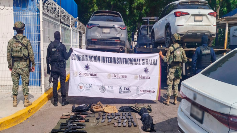 Elementos del Ejército y de la Policía Municipal resguardan los vehículos y armas asegurados.