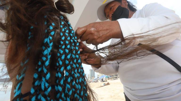 Magdalena es una mujer guerrerense que invita a los visitantes a trenzar su cabello en las playas de Mazatlán.