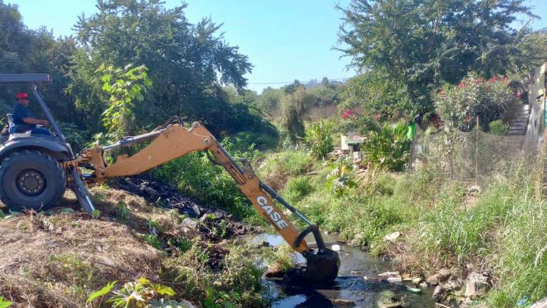 Cuadrillas de trabajadores apoyados con el apoyo de una máquina retro excavadora retiraron maleza y basura del cuerpo de agua.