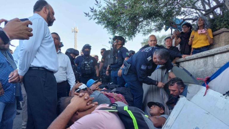 Funcionarios del gobierno de Ciudad Juárez desalojaron a personas migrantes que acampaban en la banqueta de la presidencia municipal, frente a la estación del INM clausurada.