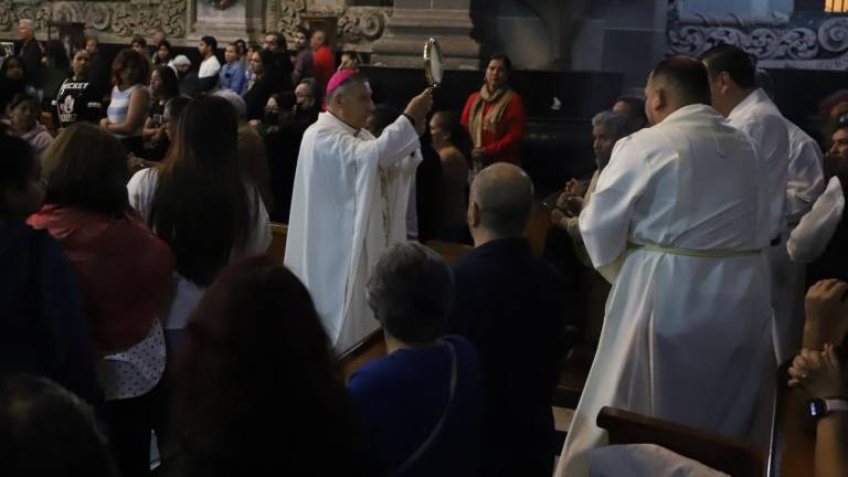 El Obispo de Mazatlán bendice a los asistentes a la Misa de la Última Cena en Catedral con la hostia consagrada.