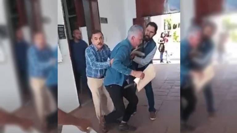 El Alcalde de Concordia, Raúl Díaz Bernal, es ayudado a levantarse tras al altercado con Ramiro Hernán, en los pasillos del Ayuntamiento.