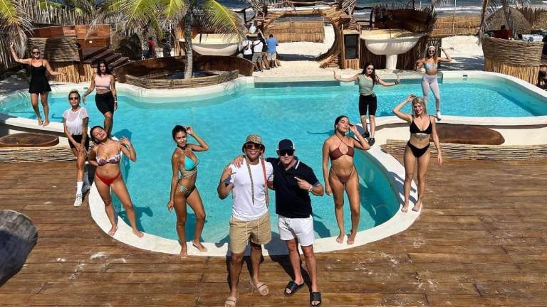 Eduin Caz junto a su socio y parte del equipo de su restaurante.