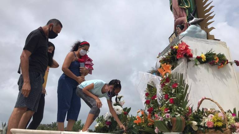 Una familia lleva ofrendas a la Virgen de la Puntilla, este miércoles.